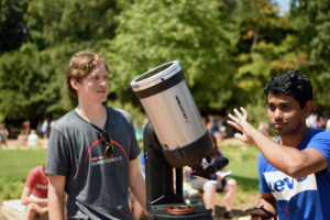 Students instruct crowd on using a special telescope