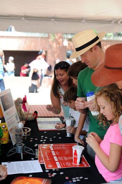 A family, gathering around a information table