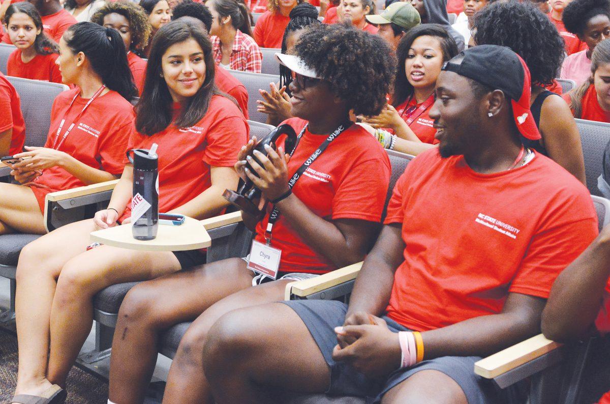 Chyra Savage, a freshman studying engineering, holds the Sankofa bird, a commemorative gift to the African American Cultural Center and symbol which represents responsibility, knowledge, love and community, while Andrea Sanchez-Zarate, a freshman studying engineering, and Will Comer, a freshman studying biological sciences, look on during the 2016 Symposium for Multicultural Scholars at the Witherspoon Cinema Friday, Aug. 12.  The bird was distributed by Toni Thorpe, Program Coordinator of the African American Cultural Center and was passed around through the audience.