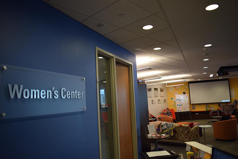 A sign that reads "Women's Center" hung on a blue wall at the entry of NC State's Women's Center