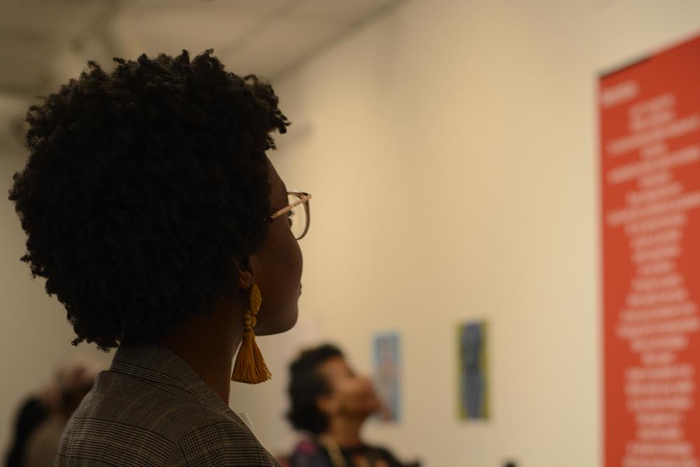 Serenity Hargrove looks at one of the pieces on display at the Politicization & Sexualization of Black Bodies art exhibit. The opening reception was held on Monday, Feb. 11 at the Witherspoon Student Center Art Gallery, and was hosted by the NC State Women's Center and the African American Cultural Center. The gallery runs until March 21, and features stories and paintings created by NC State students and staff.