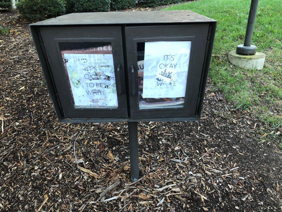 "It's Okay to be White" flyers located in a Nubian Message and Technician newsstand.