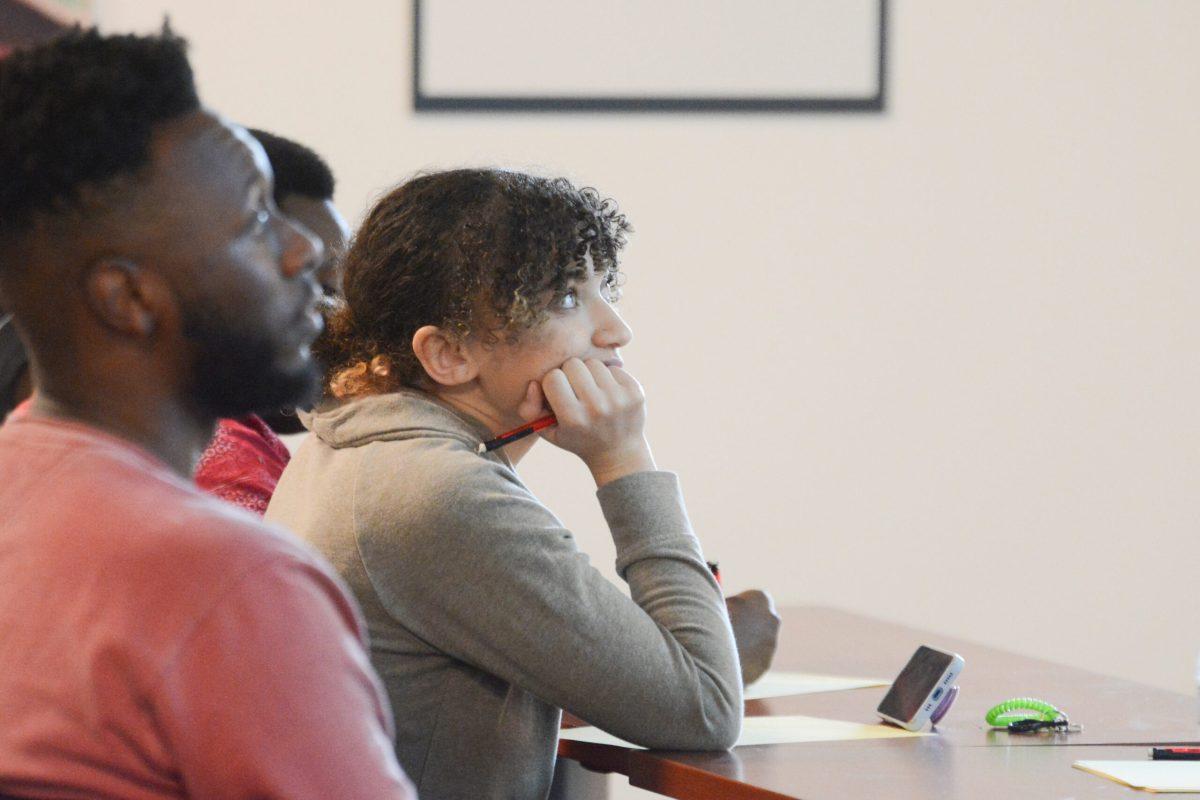 Alianna Kendall-Brooks, first-year studying political science, watches a presentation during the HerBlackHand Poetry Workshop in the African American Cultural Center Gallery on Friday, Sept. 16, 2022.