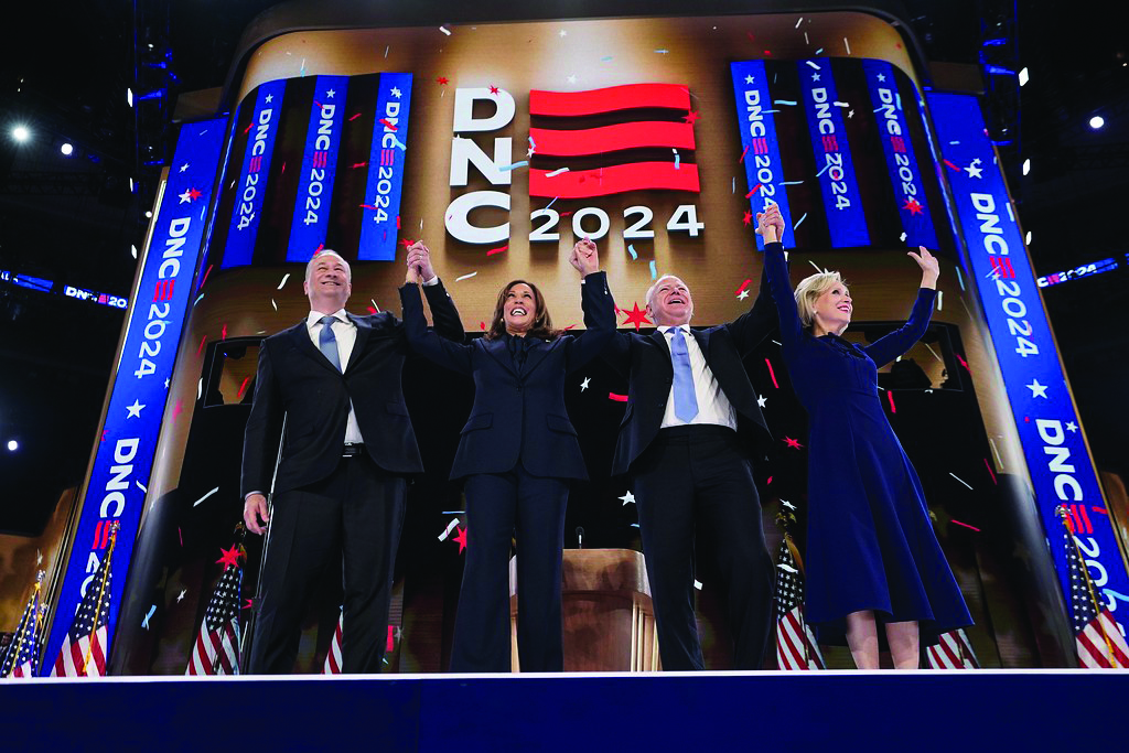 (From left to right) Doug Emhoff, Kamala Harris, Tim Walz and Gwen Walz raise hands on stage at the 2024 Democratic National Convention. 