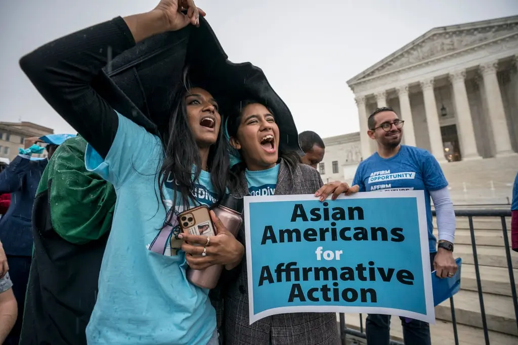 Image of two woman holding a sign saying "Asian American for Affirmative Action" during a protest from Creative Commons            