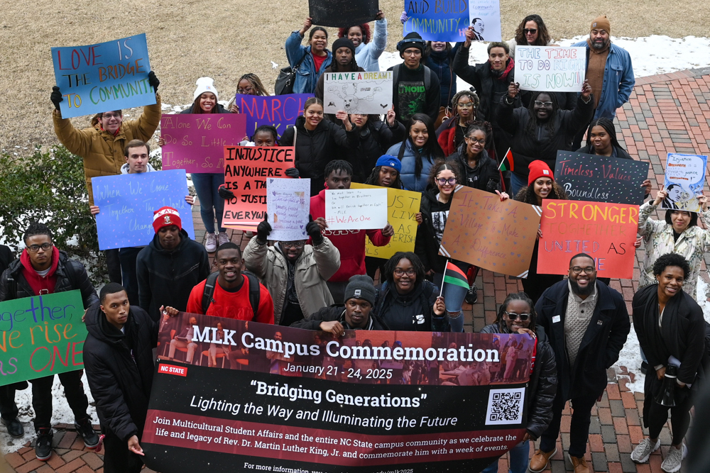 Students hold up their signs during March Like Martin at Harris Field on Friday, Jan. 24, 2025. March Like Martin was held by the African American Cultural Center and Multicultural Student Affairs. Organizers provided sign making supplies for students in order to march across campus.