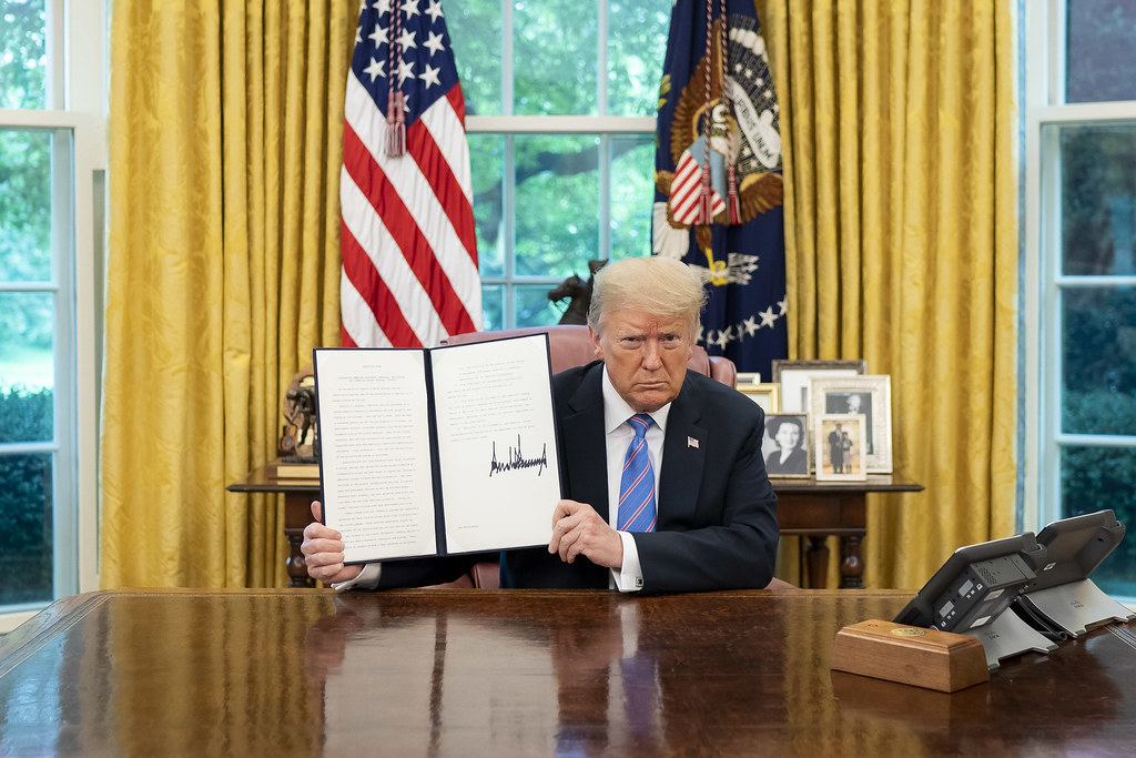 Photo of Trump signing an executive order in 2020 from Creative Commons