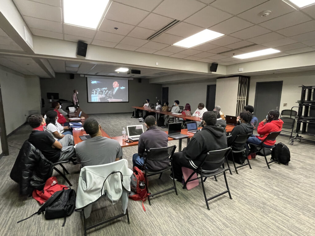 Black Male Initiative residents watch a video on Black historical figures during a class