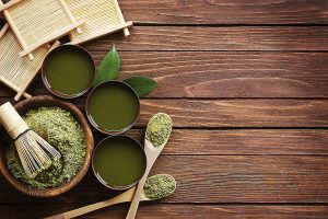 Picture of matcha powder in bowl with other cups of matcha