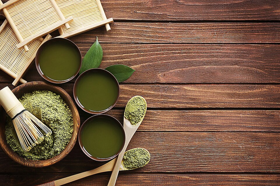 Picture of matcha powder in bowl with other cups of matcha