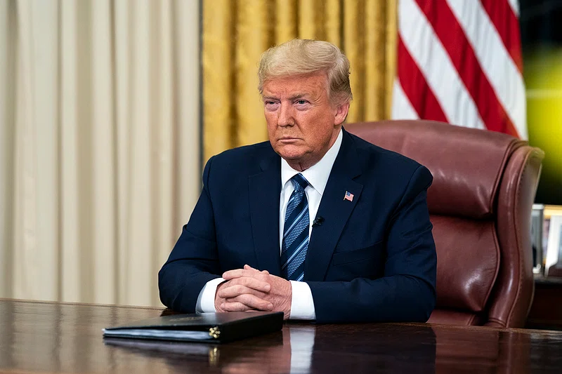 Trump sitting after signing an executive order