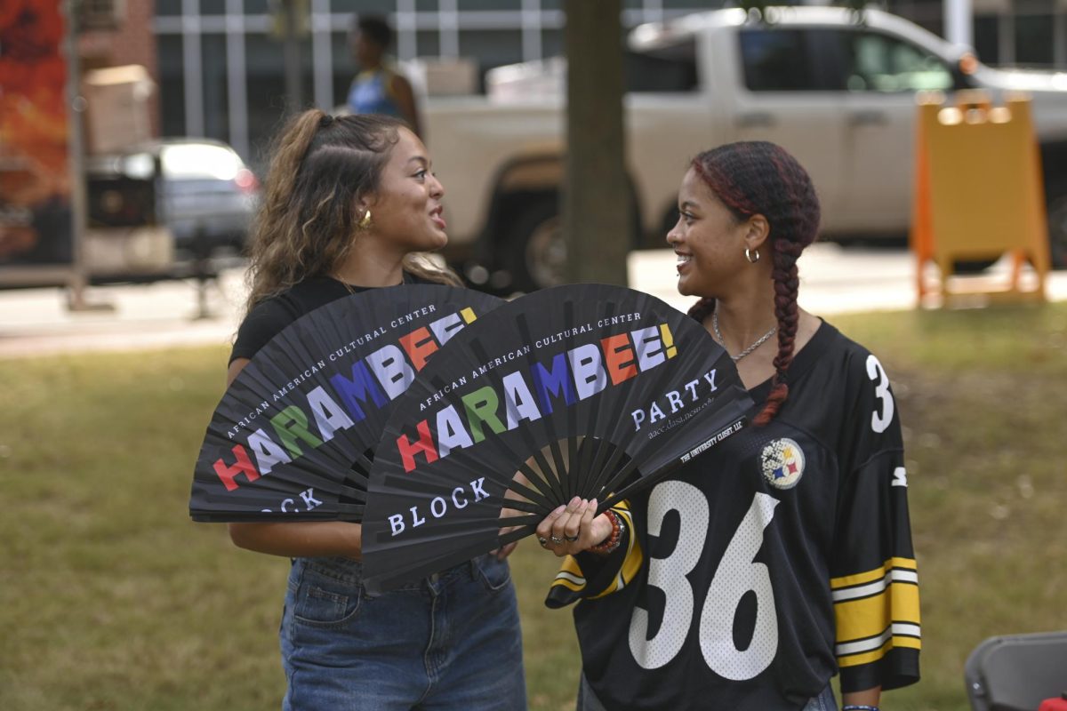 Mary-Riley Locklear, a second-year studying criminology, and Kia Nicanor a second-year studying psychology and social work, chat about the festivities during the Harambee Block Party in Harris Field on Friday, Sept, 26, 2025. During the event food trucks came out with a variety of food options to enjoy.