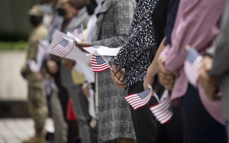 A row of people holding American flags.