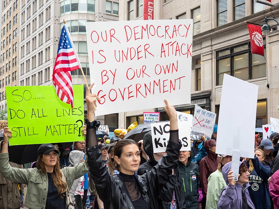 A protester holding up a sign at a No Kings protest.