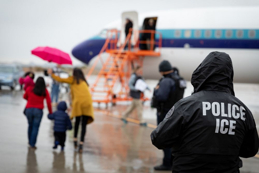 An ICE agent standing in front of a plane